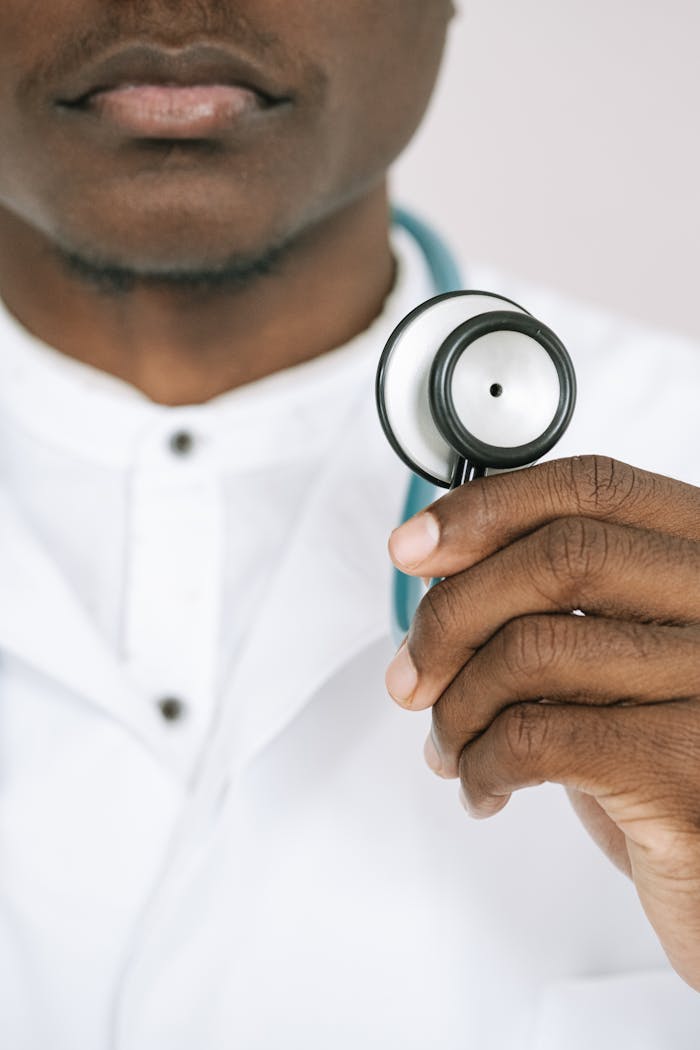 Home Doctor holding a stethoscope in close-up, showcasing healthcare professionalism.