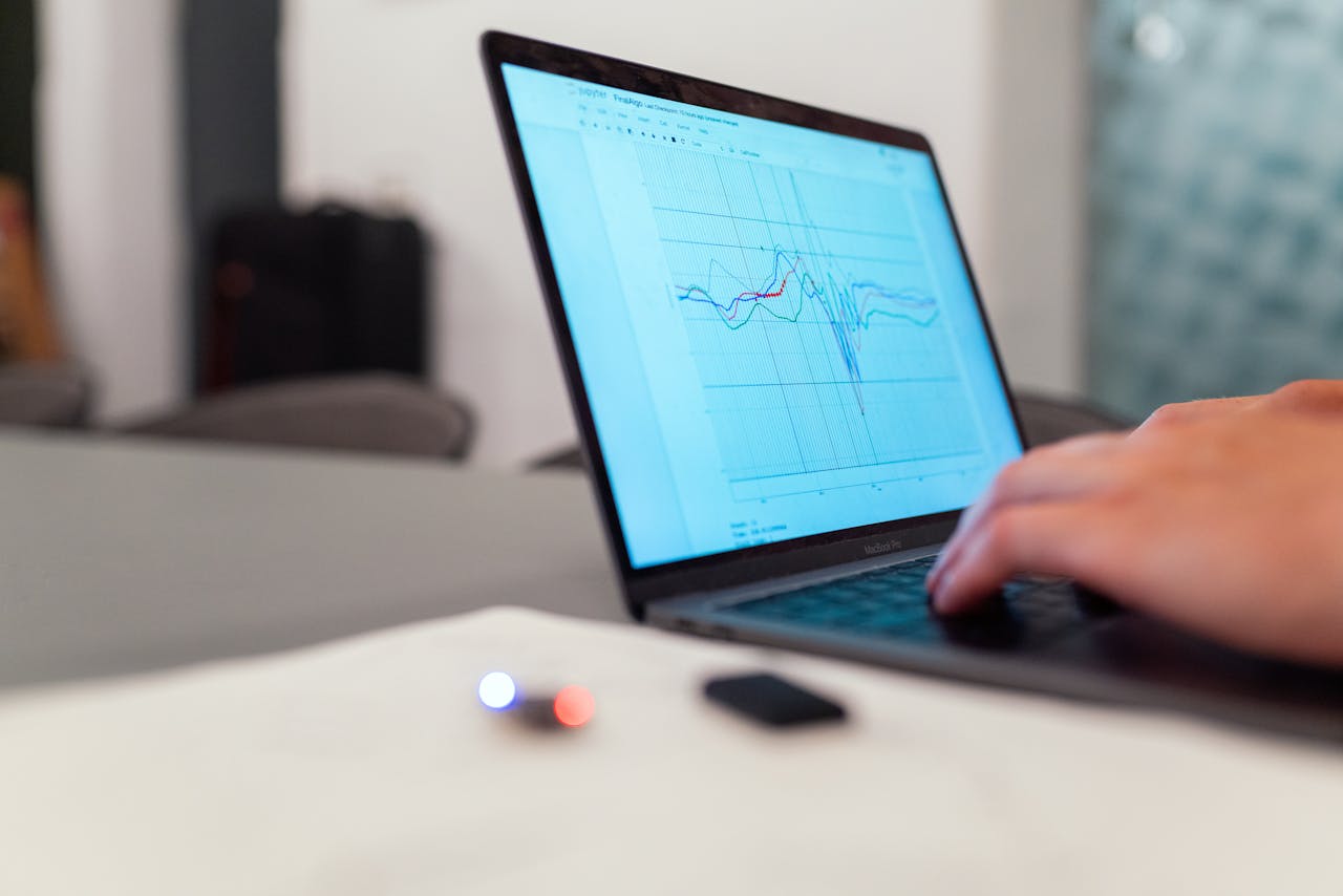 Home A person working on a graph analysis on a laptop for data monitoring and research.