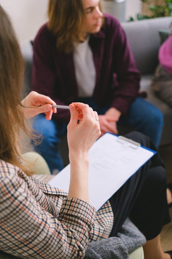 Blog A therapist with a clipboard conducting a counseling session with clients.